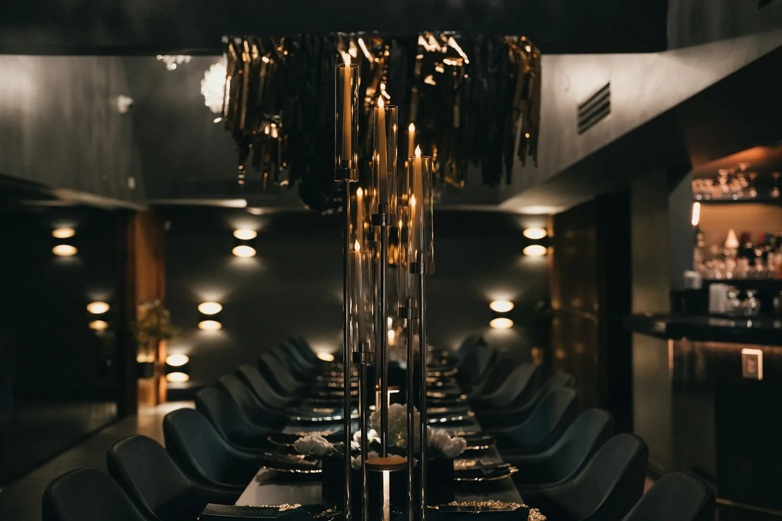 Salle à manger boisée aux chandelles, longue table dressée.